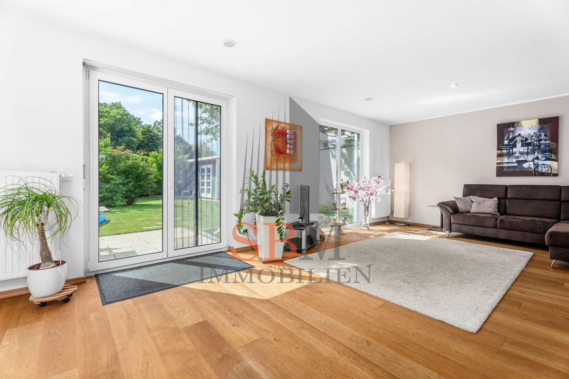 Familiendomizil im modernen Stil mit charmantem Garten und Top-Anbindung - Wohnzimmer mit Blick in den weitläufigen Garten